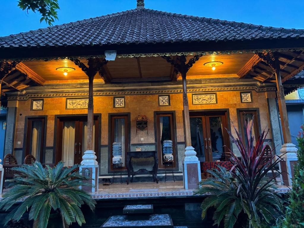 a house with a porch with palm trees at Khailash Warung and Home Stay in Sidemen