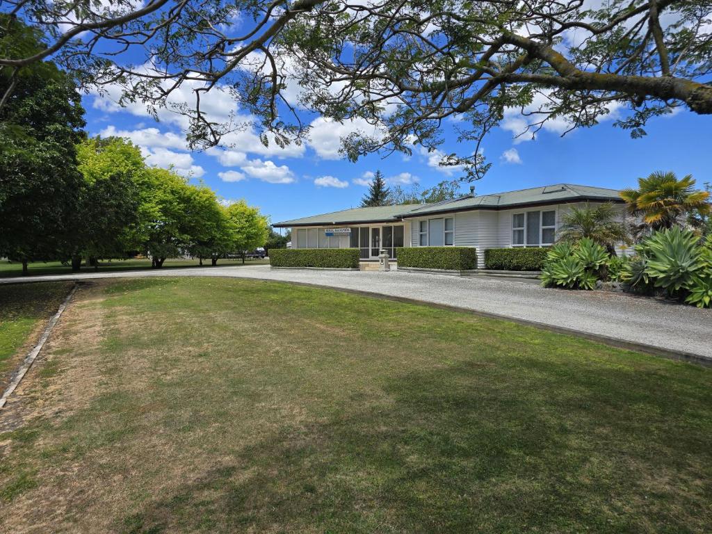 ギズボーンにあるSunnydays Motelの前に広い庭がある家