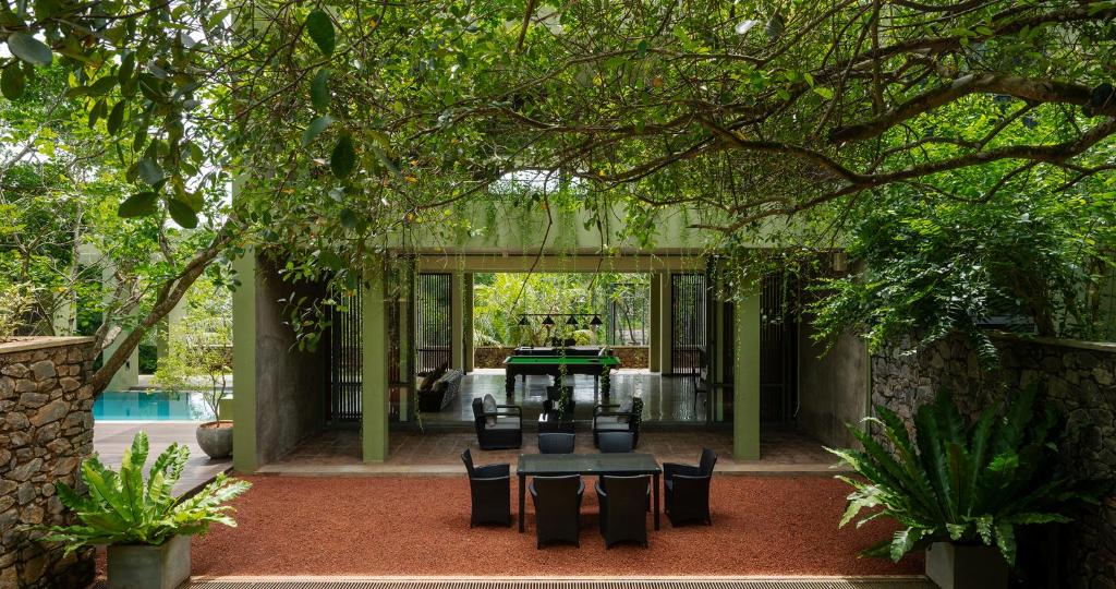a patio with a table and chairs and a pool at Villa 98 in Malabe