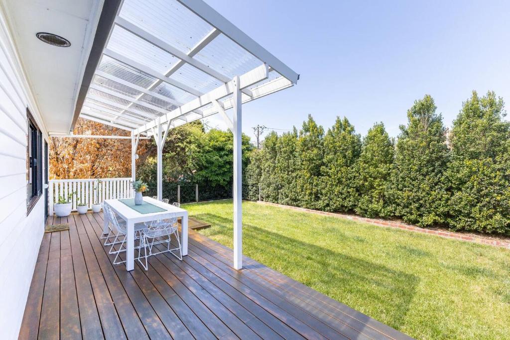 a patio with a white table on a wooden deck at Oaklight Haven - Minutes to Geelong Waterfront & CBD in Hamlyn Heights