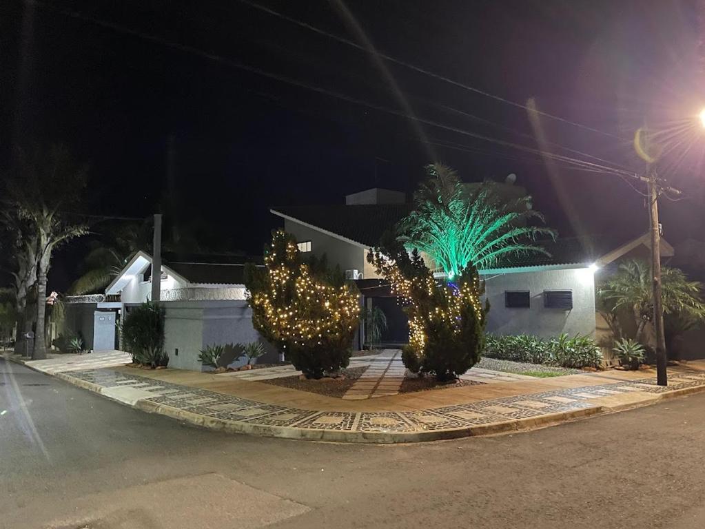 a street at night with trees decorated with lights at Bela Casa Stella Maris - Casa de Carrara 01 in Andradina