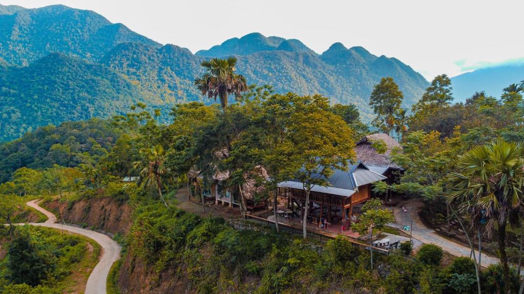 ein Haus auf einem Hügel mit Bergen im Hintergrund in der Unterkunft Pu Luong - Duy Phuong Homestay in Thanh Hóa