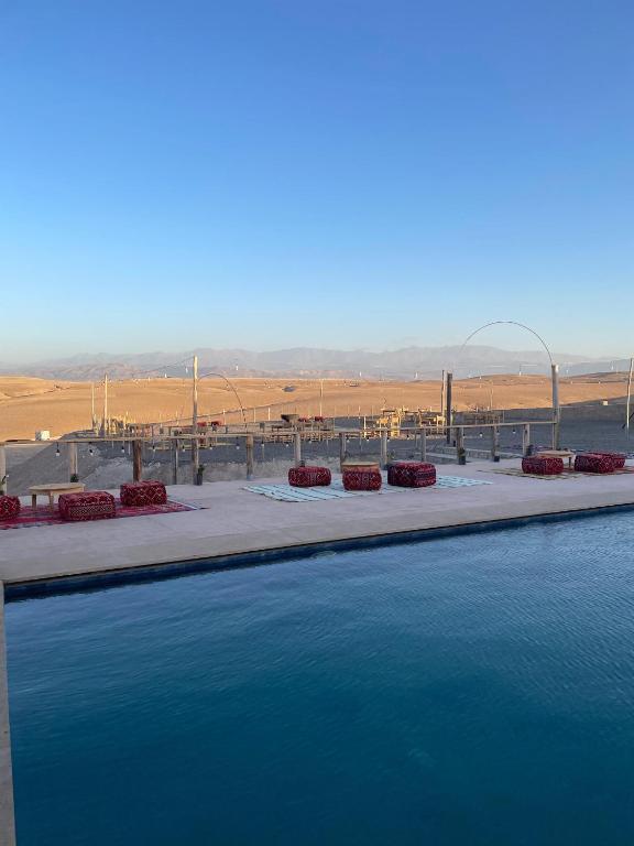 a large pool of water with a view of the desert at ITRANE Agafay in Marrakesh
