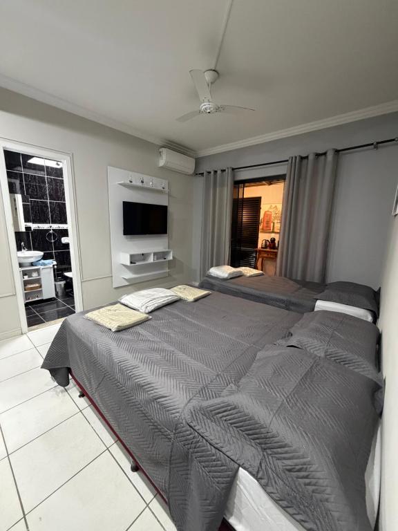 a bedroom with a large bed and a television at Loft BC ESTÚDIO Centro in Balneário Camboriú