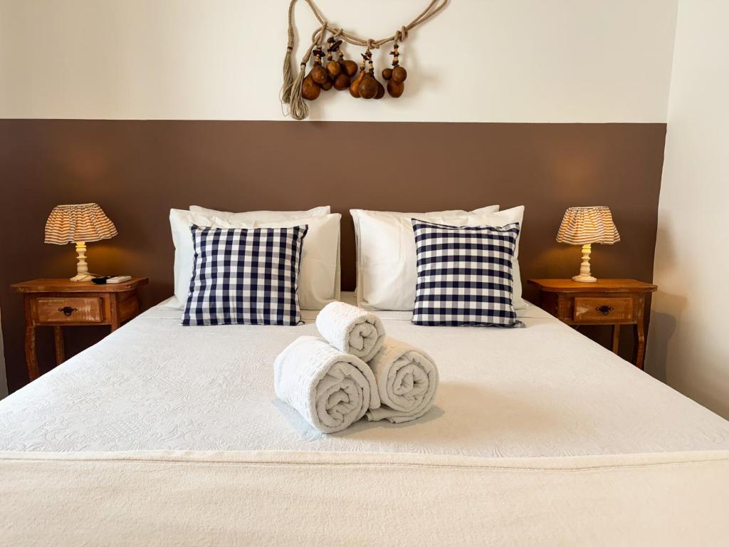 een slaapkamer met een bed met handdoeken erop bij Vila Saruê in Búzios