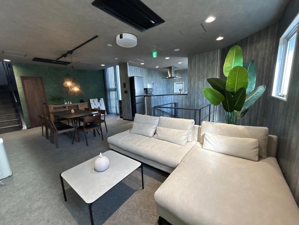 ein Wohnzimmer mit Sofa und Tisch in der Unterkunft マイグレ南青山 in Tokio