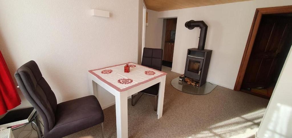 een kamer met een tafel en een houtkachel bij Glorios in Heiden