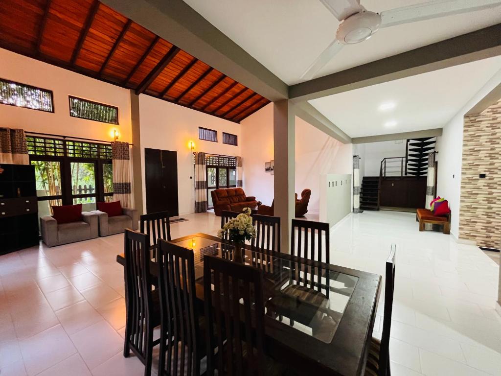 Un comedor y una sala de estar con mesa y sillas. en Hidden Gem - Private Villa, en Tangalle
