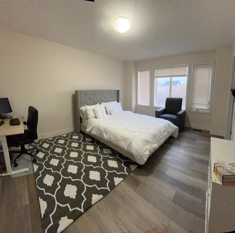 Schlafzimmer mit einem Bett, einem Schreibtisch und einem Stuhl in der Unterkunft Luxurious & Spacious 4-Bedroom Vacation Home in Edmonton
