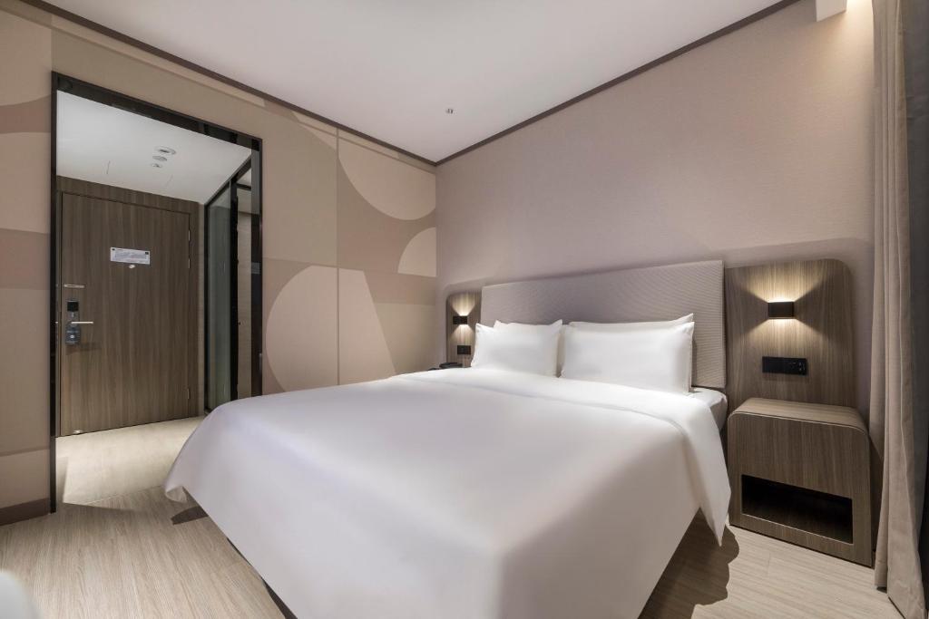 Postel nebo postele na pokoji v ubytování Hanting Hotel Shanghai South Station East China University of Science and Technology