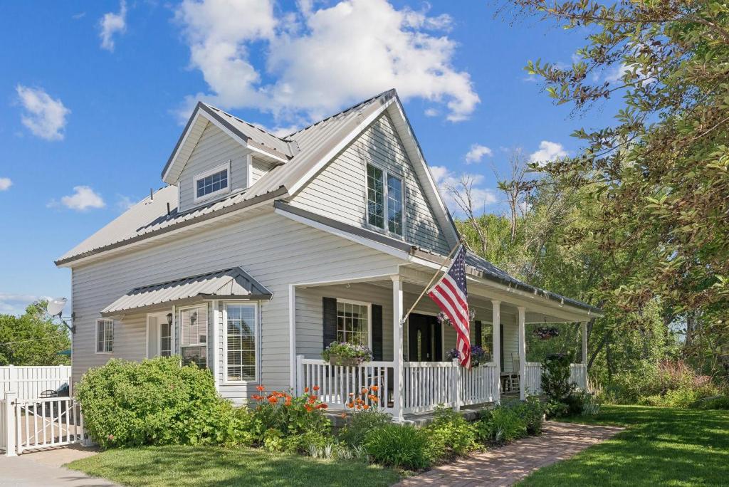 a white house with an american flag on it at Creekside cutie 3br 2.5ba near skiing sleeps 8 in Kamas