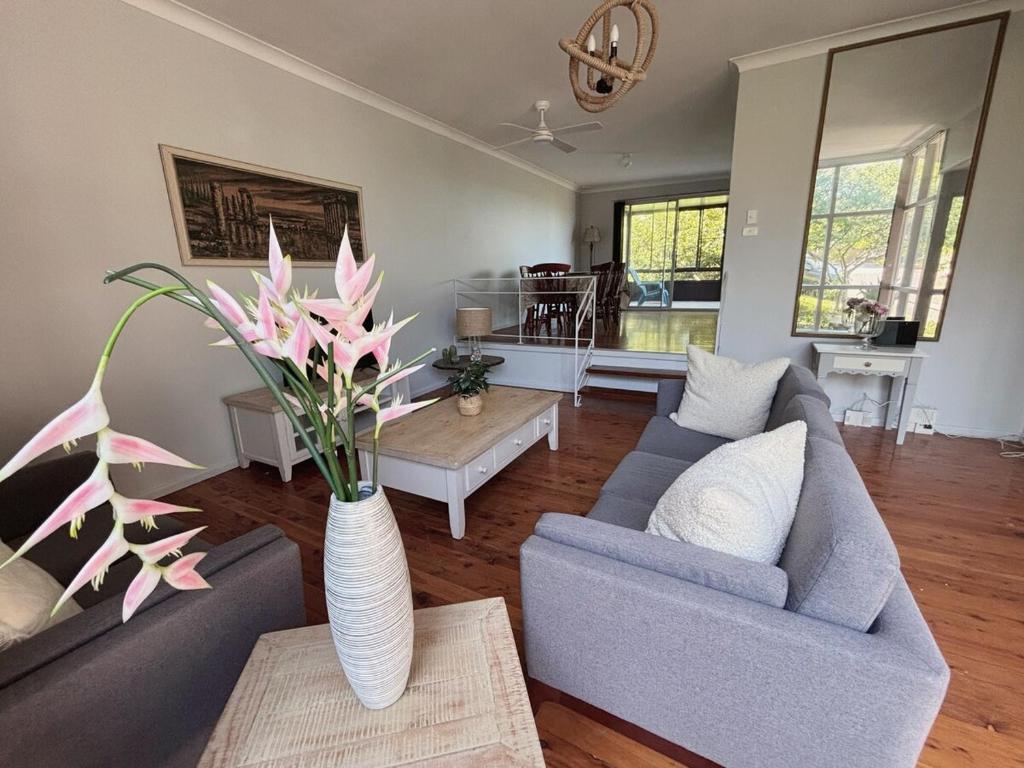 a living room with two couches and a vase with flowers at Bright & Spacious Getaway - East Gosford in Point Frederick