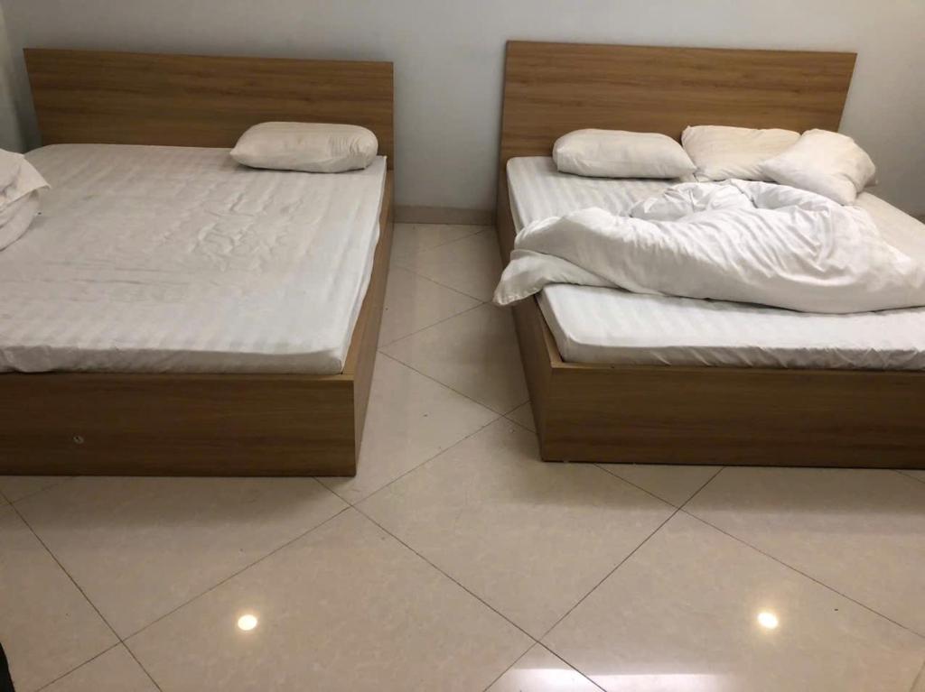 zwei nebeneinander stehende Betten in einem Schlafzimmer in der Unterkunft Classic Hotel in Hanoi