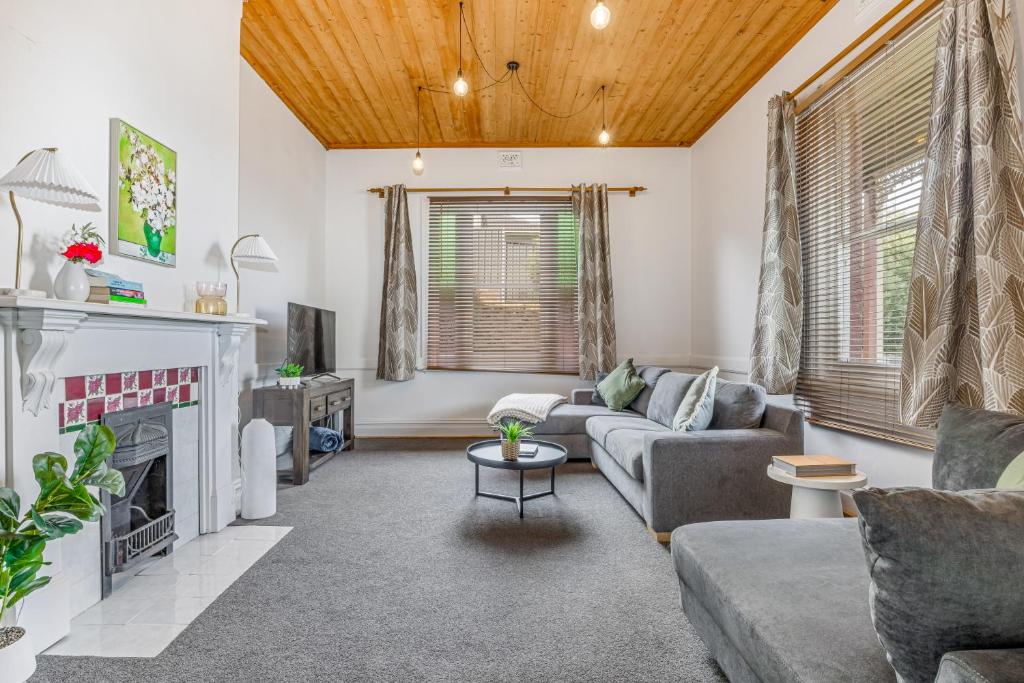 a living room with a couch and a fireplace at Bendigo Signature Accommodation on Vine in Bendigo