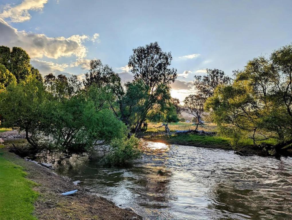 a river with trees on the side of it at Colac Colac Caravan Park in Corryong