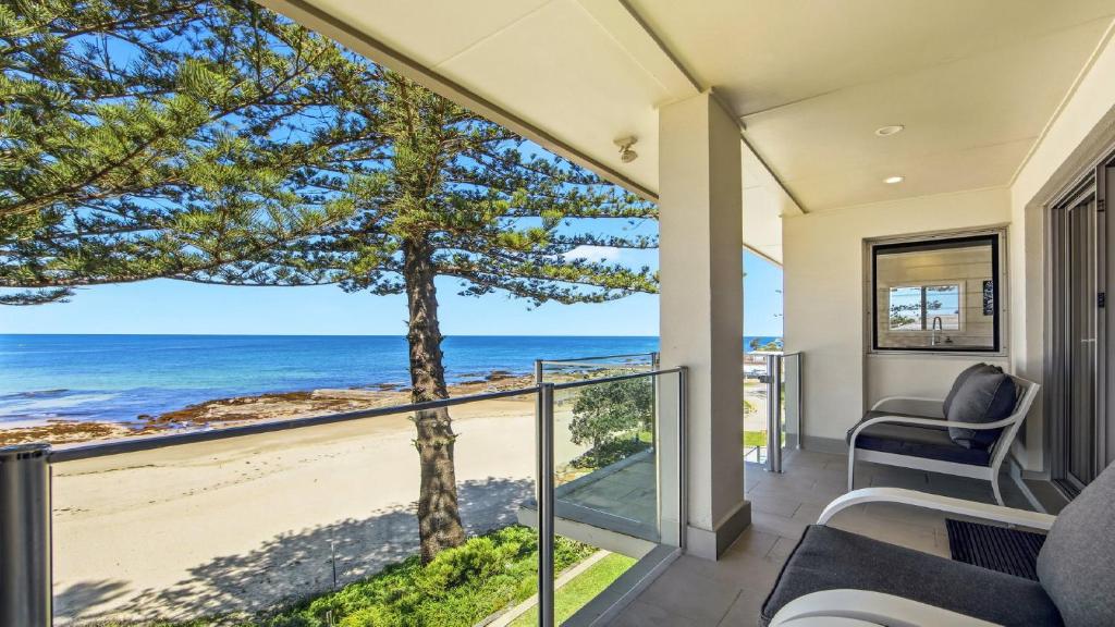 a living room with a view of the ocean at Beachfront Breeze - Family Getaway By Holidayco in The Entrance
