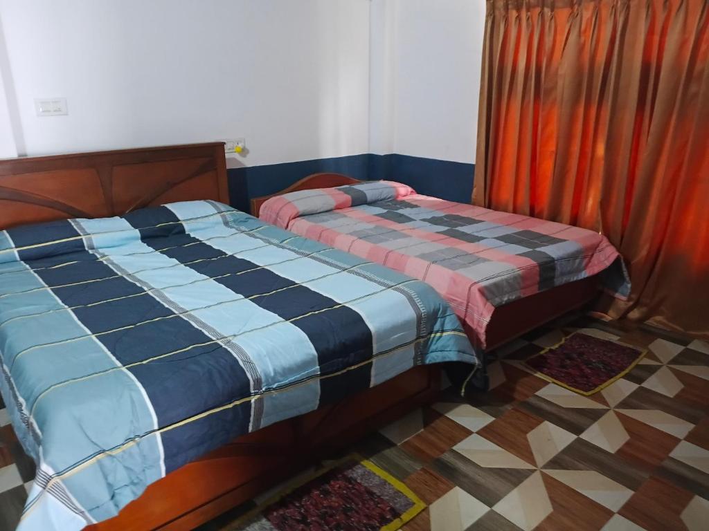 une chambre avec deux lits jumeaux dans une pièce dans l'établissement Varshini home stay, à Kotagiri