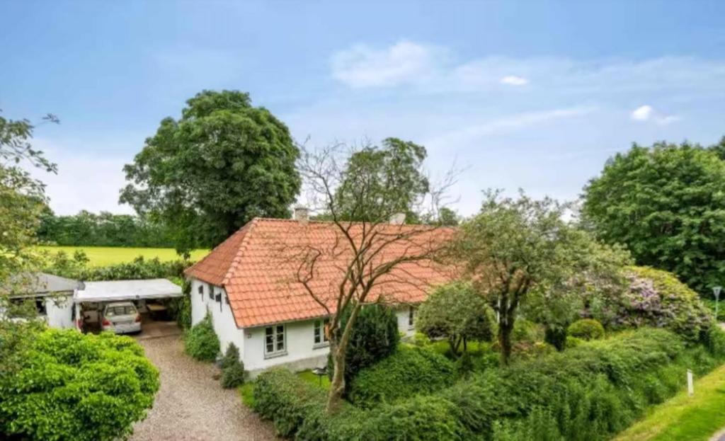 a white house with a red roof at Hyggelig Hus Nær Arrild Ferieby in Arrild