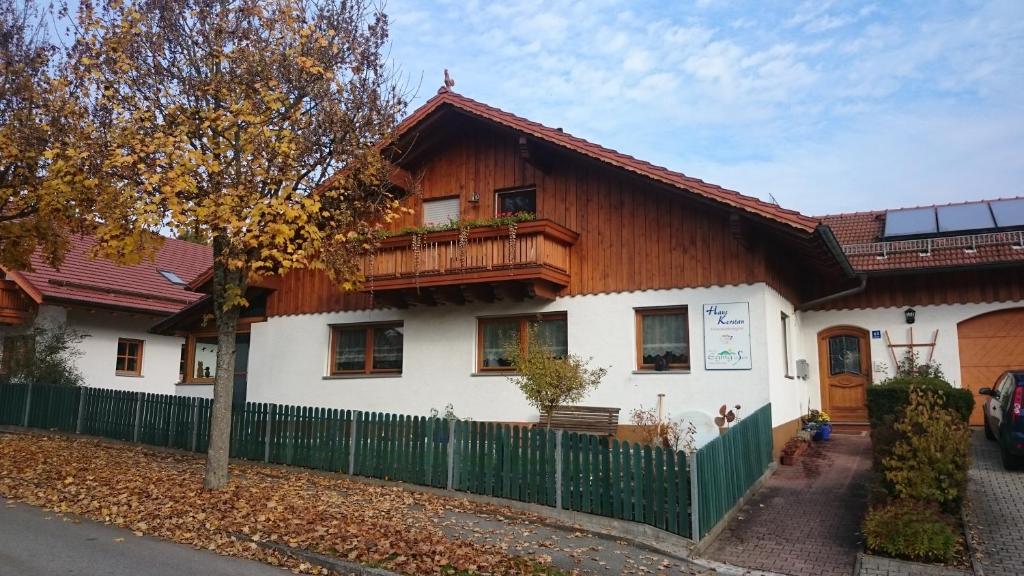 ein weißes Haus mit einem Holzdach in der Unterkunft Haus Kerstan in Eging