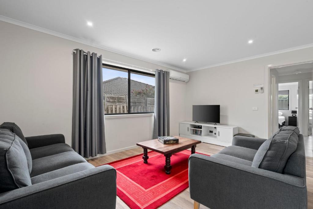 a living room with two couches and a table at Time to Relax in Portarlington