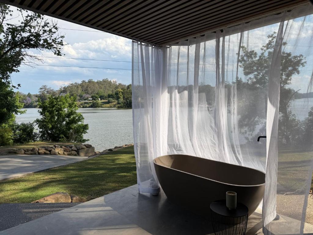 a bath tub sitting in front of a window at Chapel Cove Retreat - Private Tiny House with Boat Ramp in Sackville Reach