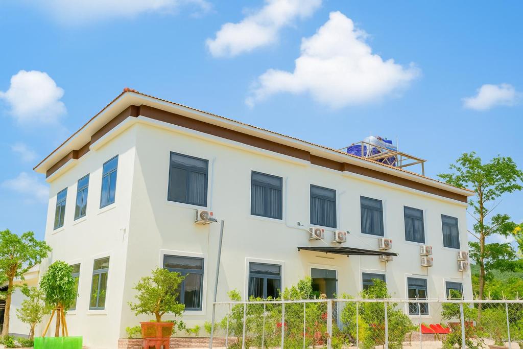 een wit gebouw met een hek ervoor bij Hoàng Đô Hotel in Phu Quoc