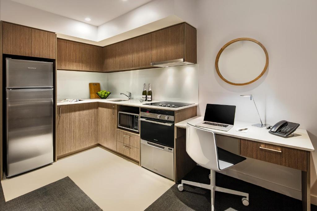 a kitchen with a desk with a laptop on it at Quest Mounts Bay Road in Perth
