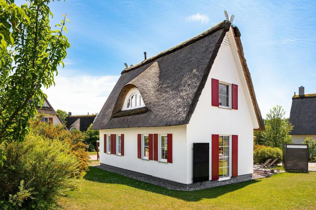 a small white house with a thatched roof at Urlaub Am Meer Im Reethaus Fabius in Gramkow