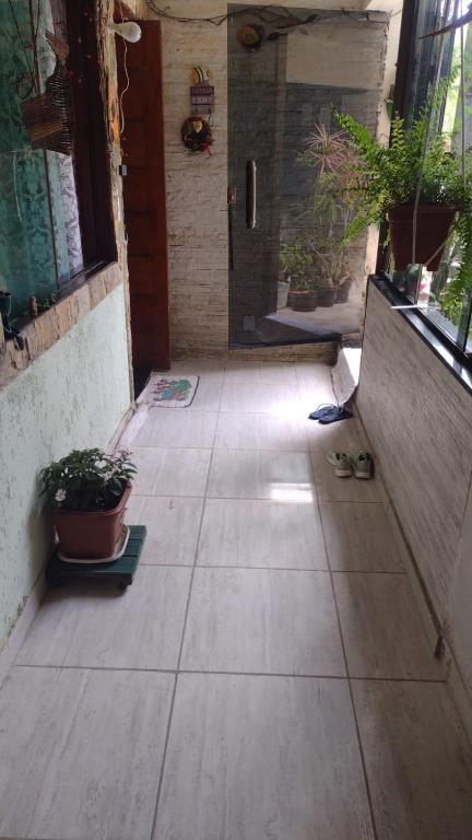 a walkway with potted plants and a door at martinshouse in Cabo Frio
