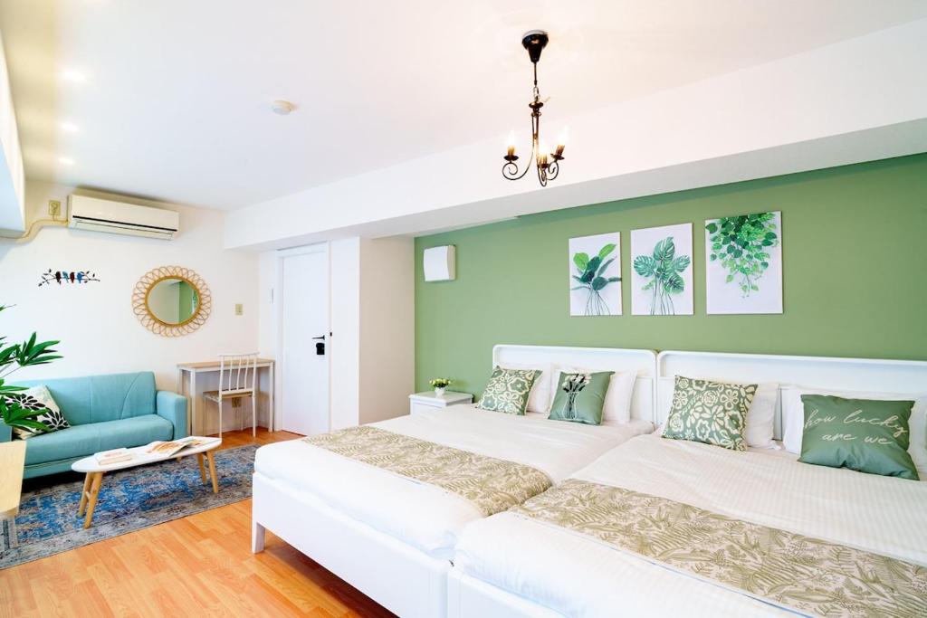 a bedroom with two beds and a couch at Higashi-Shinjuku 904 in Tokyo