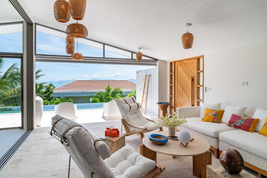 d'un salon avec un mobilier blanc et une vue sur l'océan. dans l'établissement 4br Villa Breeze Tropical Sea View Retreat, à Ban Bang Po