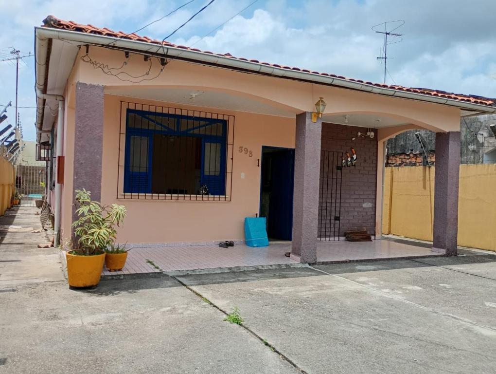 a small house with a yellow door on a street at Casa Mosqueiro in Belém