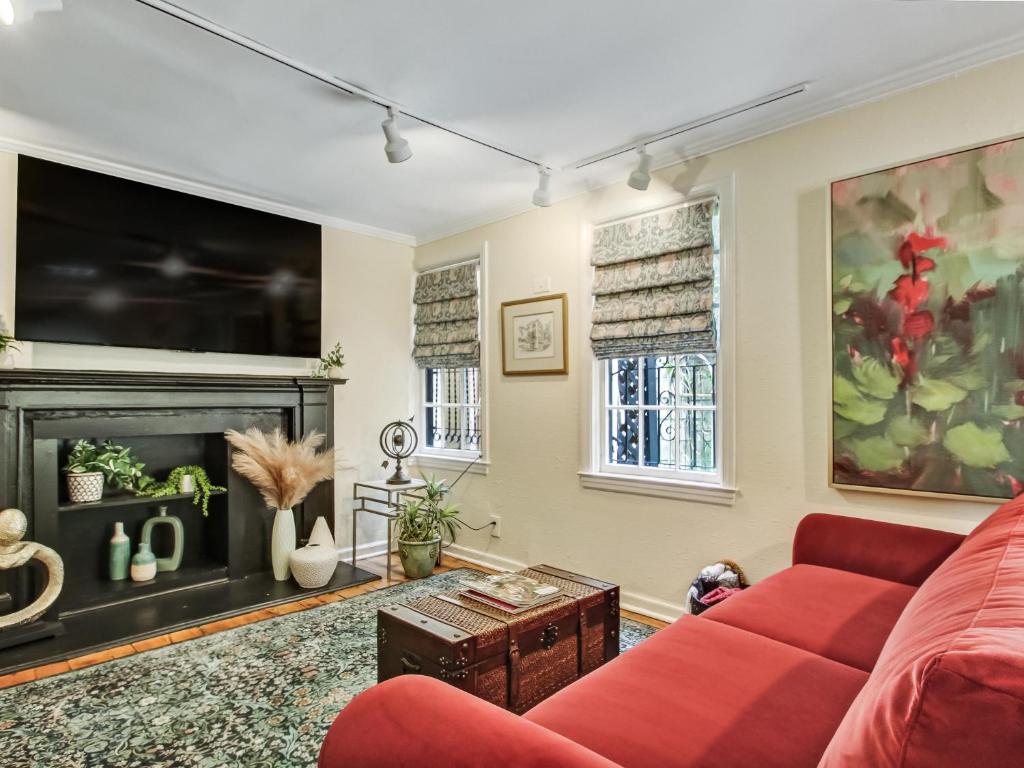 a living room with a red couch and a fireplace at Courtyard Off Madison Square in Savannah