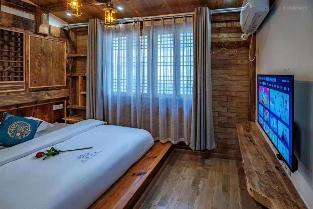 a bedroom with a large bed and a large window at Huazhu Baihe Huagu Inn in Wang-ts'un