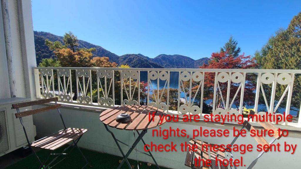 a balcony with a table and a view of the mountains at プチホテル　MASUYA in Nikko
