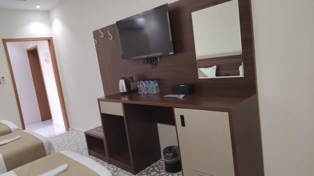 a room with a desk with a tv and a mirror at فندق بارك الياس in Aţ Ţunḑubāwī