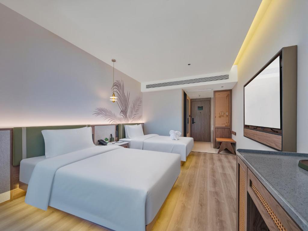 a bedroom with a white bed and a living room at Lijiang Gucheng District RIM Hotel in Lijiang