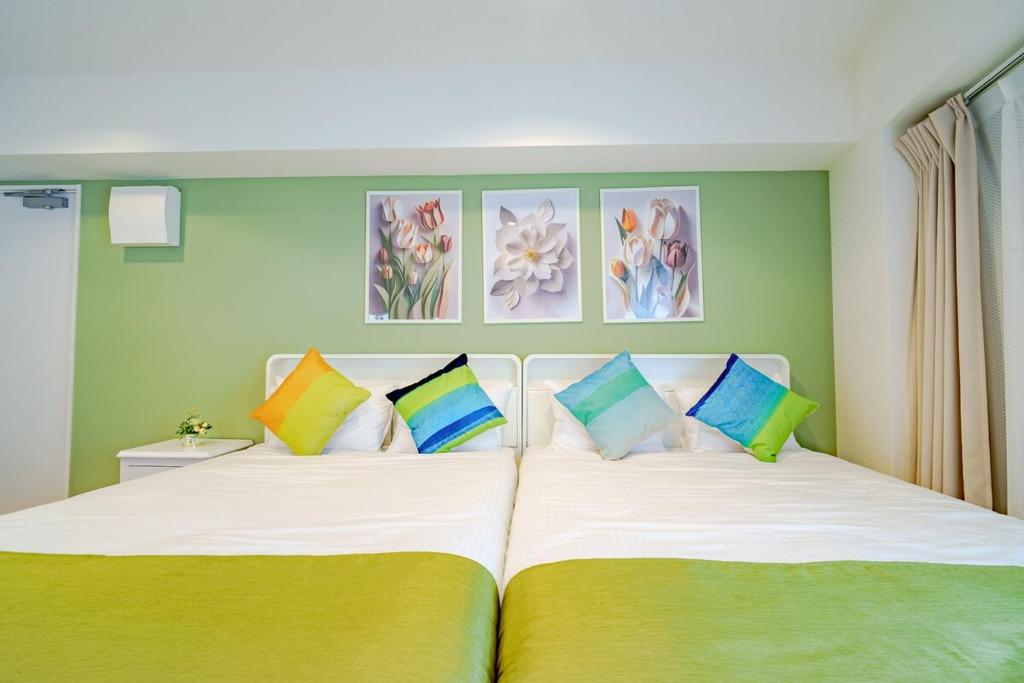 a bedroom with two beds with colorful pillows at Higashi-Shinjuku 906 in Tokyo