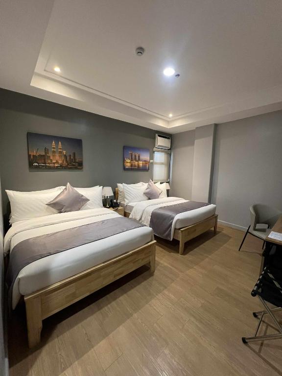 a bedroom with two beds in a room at Doña Manor Boutique Hotel in Olongapo