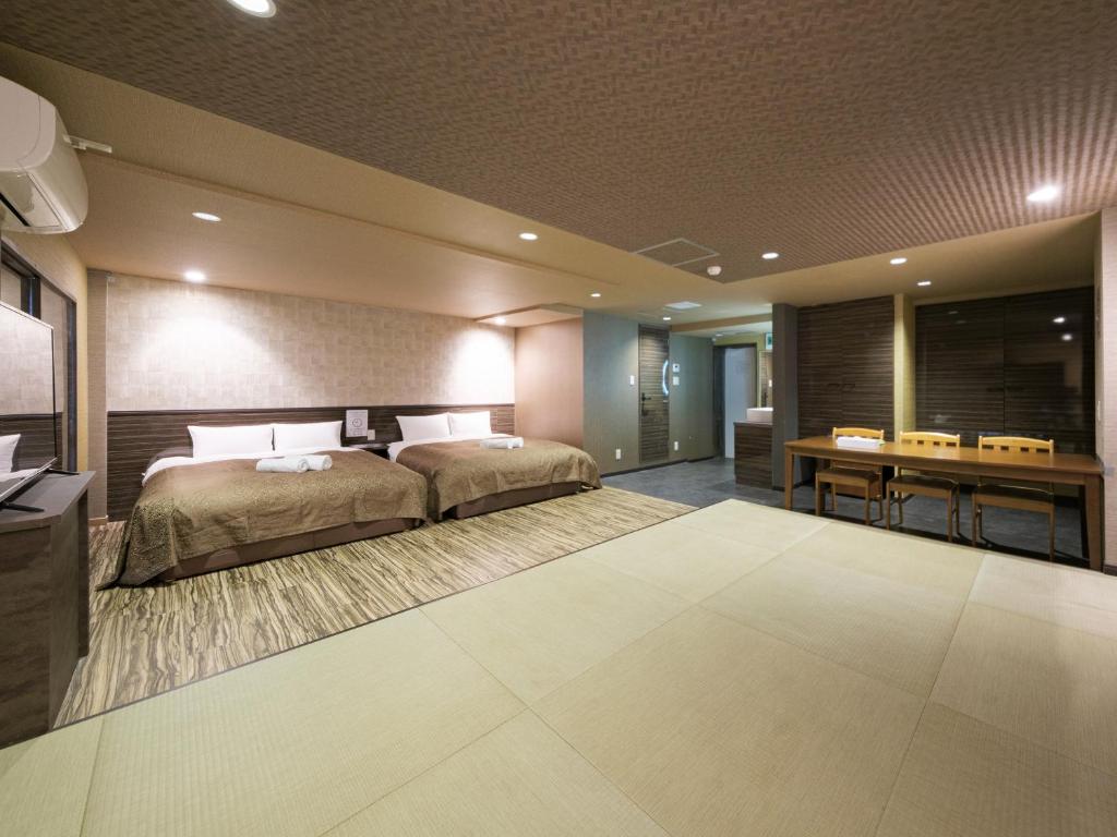 a large bedroom with a bed and a desk at Tomaru House J in Chiba