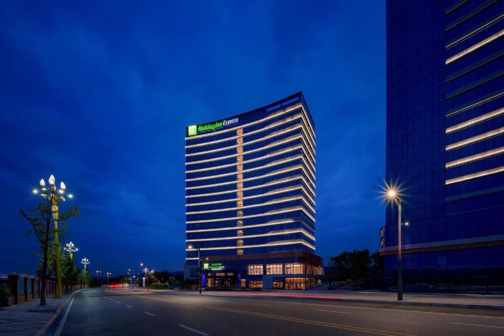 un grand bâtiment avec une enseigne sur le côté dans l'établissement Holiday Inn Express Chongqing Liangjiang Yufu by IHG, à Chongqing