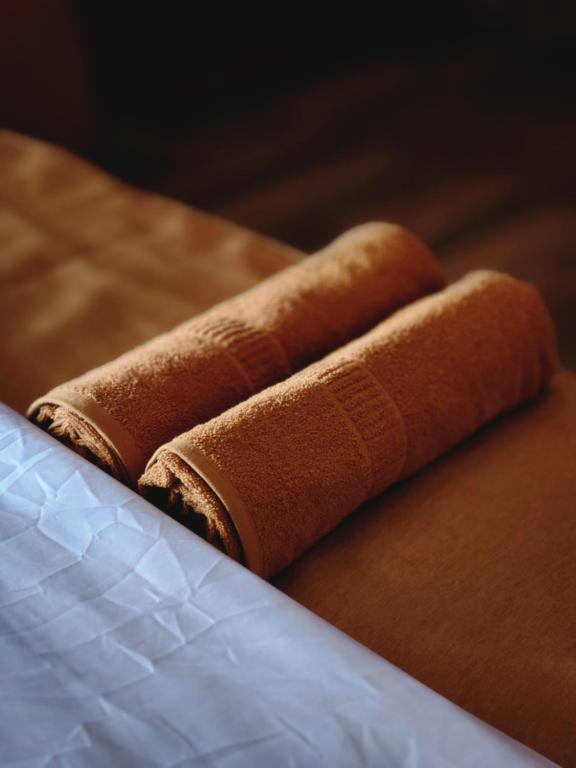 twee bruine handdoeken bovenop een tafel bij Tea Brook Lodge Ella in Ella