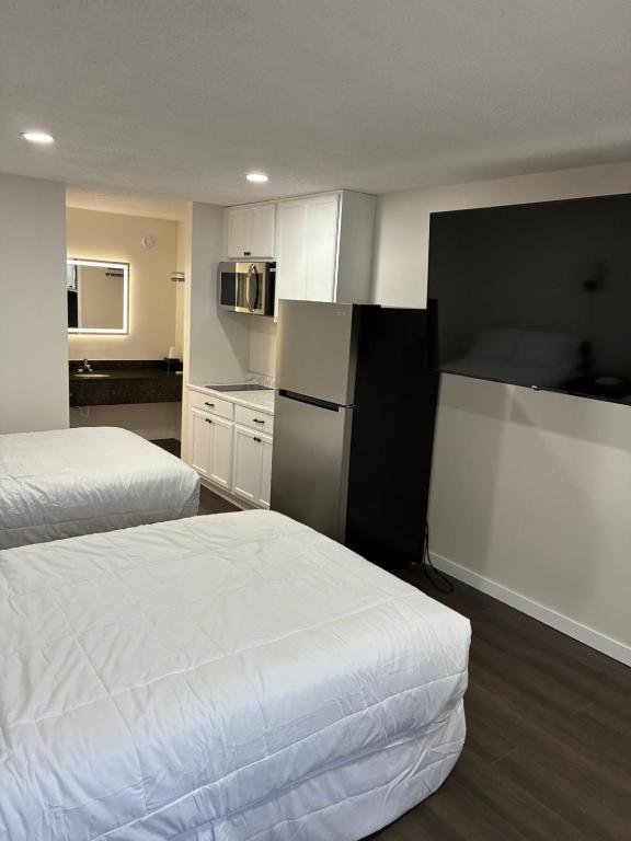 a hotel room with two beds and a refrigerator at Suite Stay in Talladega