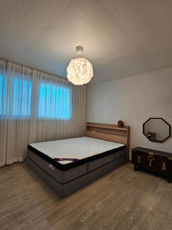 a bedroom with a bed and a chandelier at 숲애스테이 in Hagwanggyo-dong