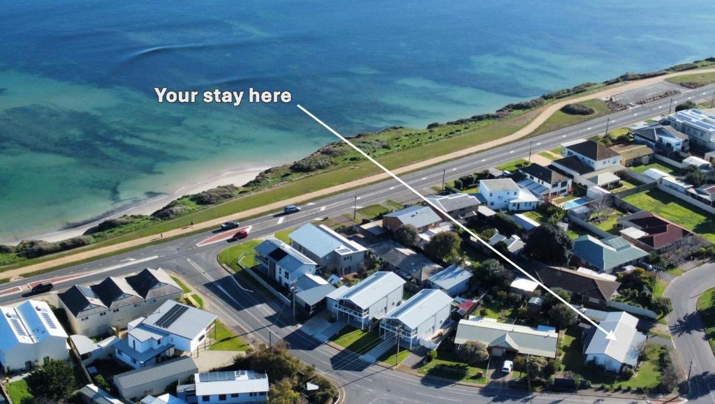 arial view of a suburb with the words your stay here at The Little Beach Retreat - Relaxing family sized home one street from the sea! in Port Willunga