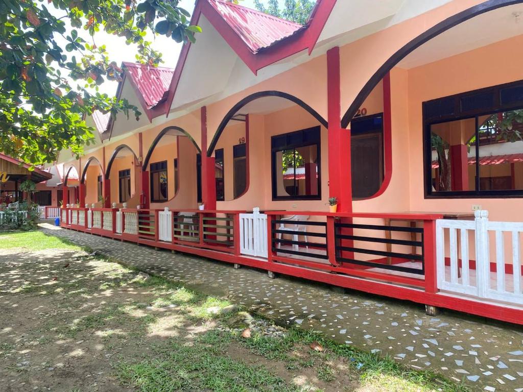 a building with red and orange paint on it at JBR Tourist Inn - Port Barton in Itaytay