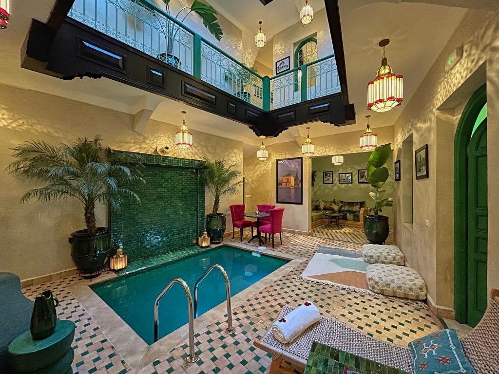 a swimming pool in a large room with a house at Riad Lia ou Lik in Marrakesh