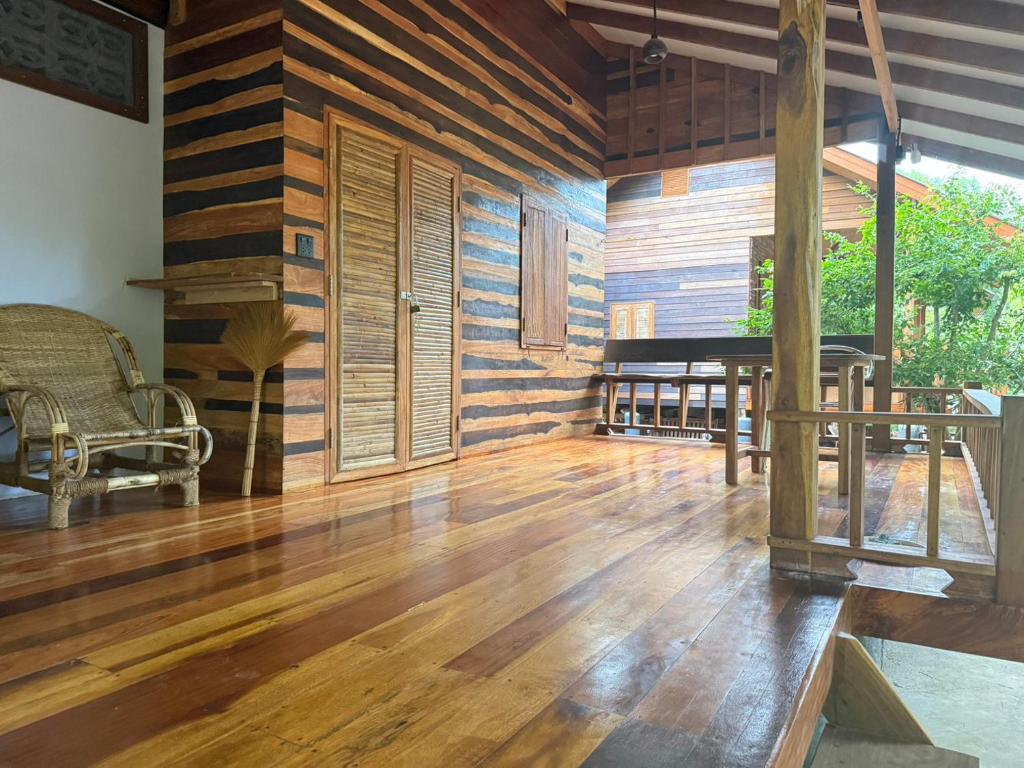 a living room with wooden walls and a wooden floor at Cocoa Home in Ban Ko Phrao