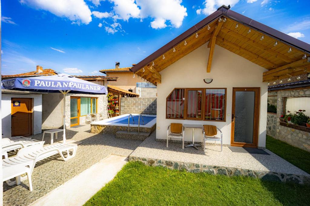 een huis met een patio en een zwembad bij Banya Guest Rooms 23 in Banya
