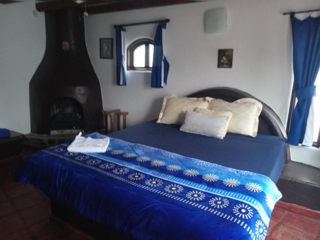 a bedroom with a blue bed with a fireplace at Exotic Oceanfront villa with Private Pool & jacuzzi - Parties & Events in Rosarito